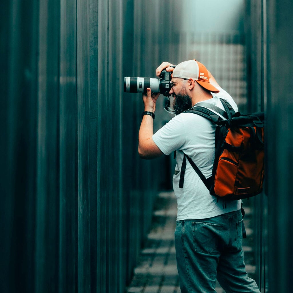 Fotografo che scatta foto all'aperto con obiettivo lungo