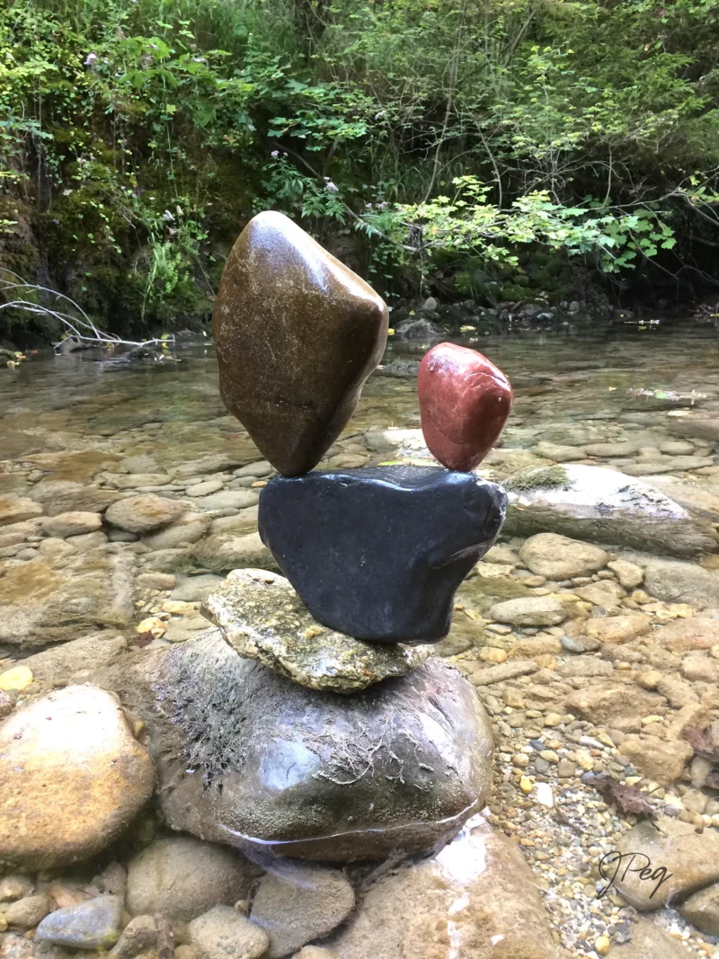 Balanced stones in a serene forest stream