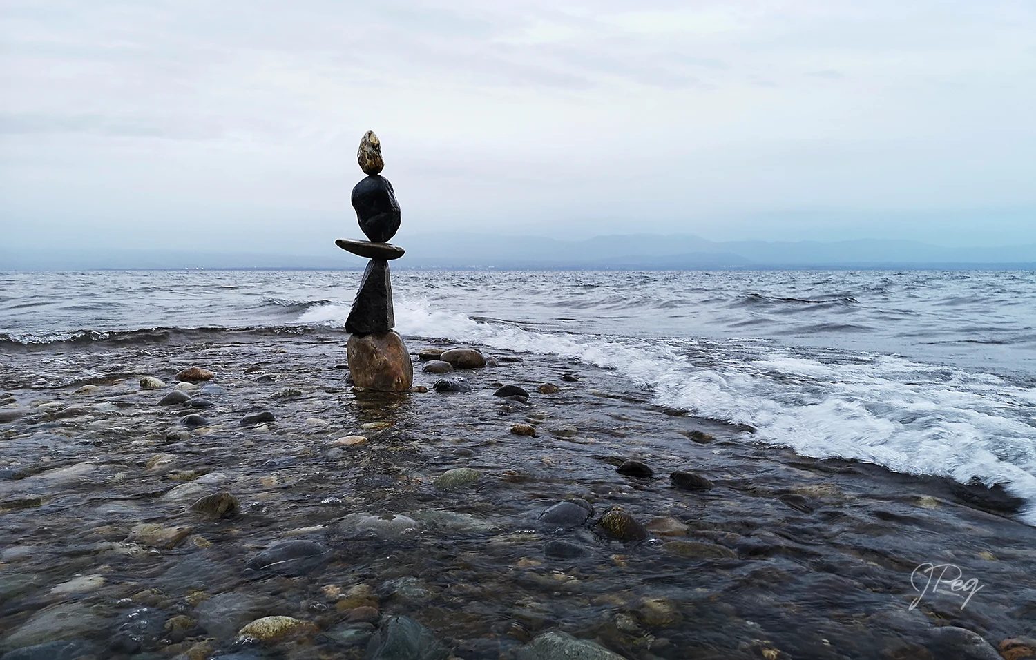 Pietre d'equilibrio in riva al mare su una spiaggia di ciottoli.