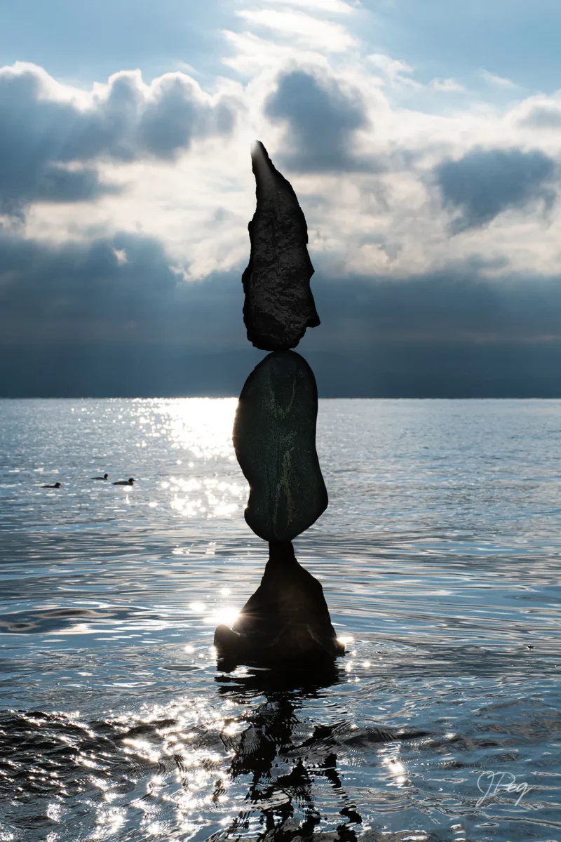 Balanced rocks on water at sunset.