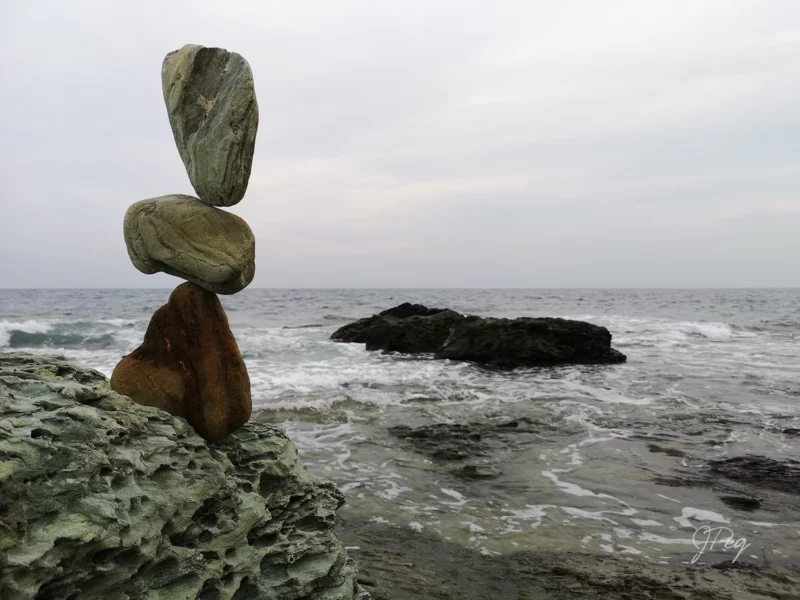 Stacked stones on a rocky, wave-lashed shore.