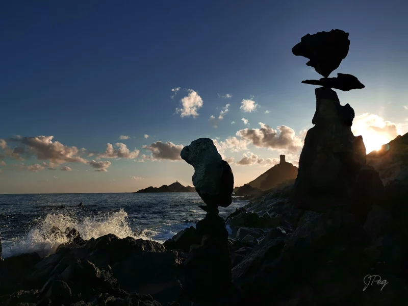 Rocce in equilibrio su una scogliera al tramonto.