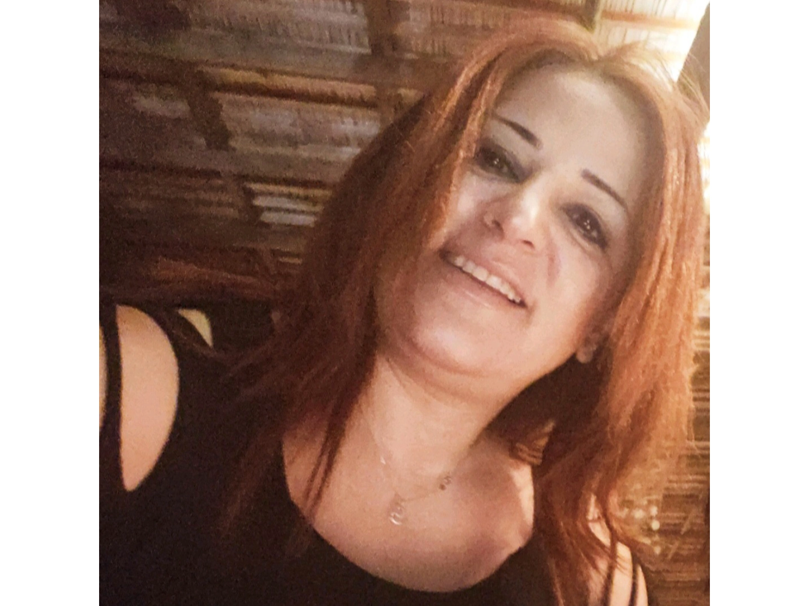 Smiling woman with auburn hair indoors