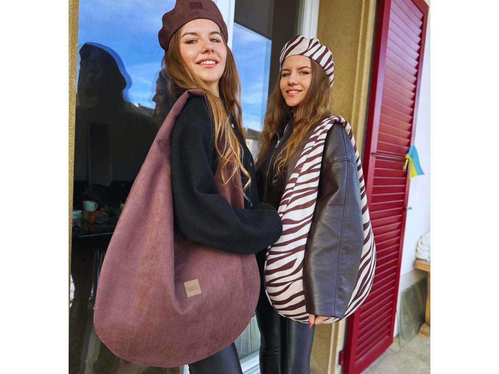 Two women modelling oversized shoulder bags outdoors