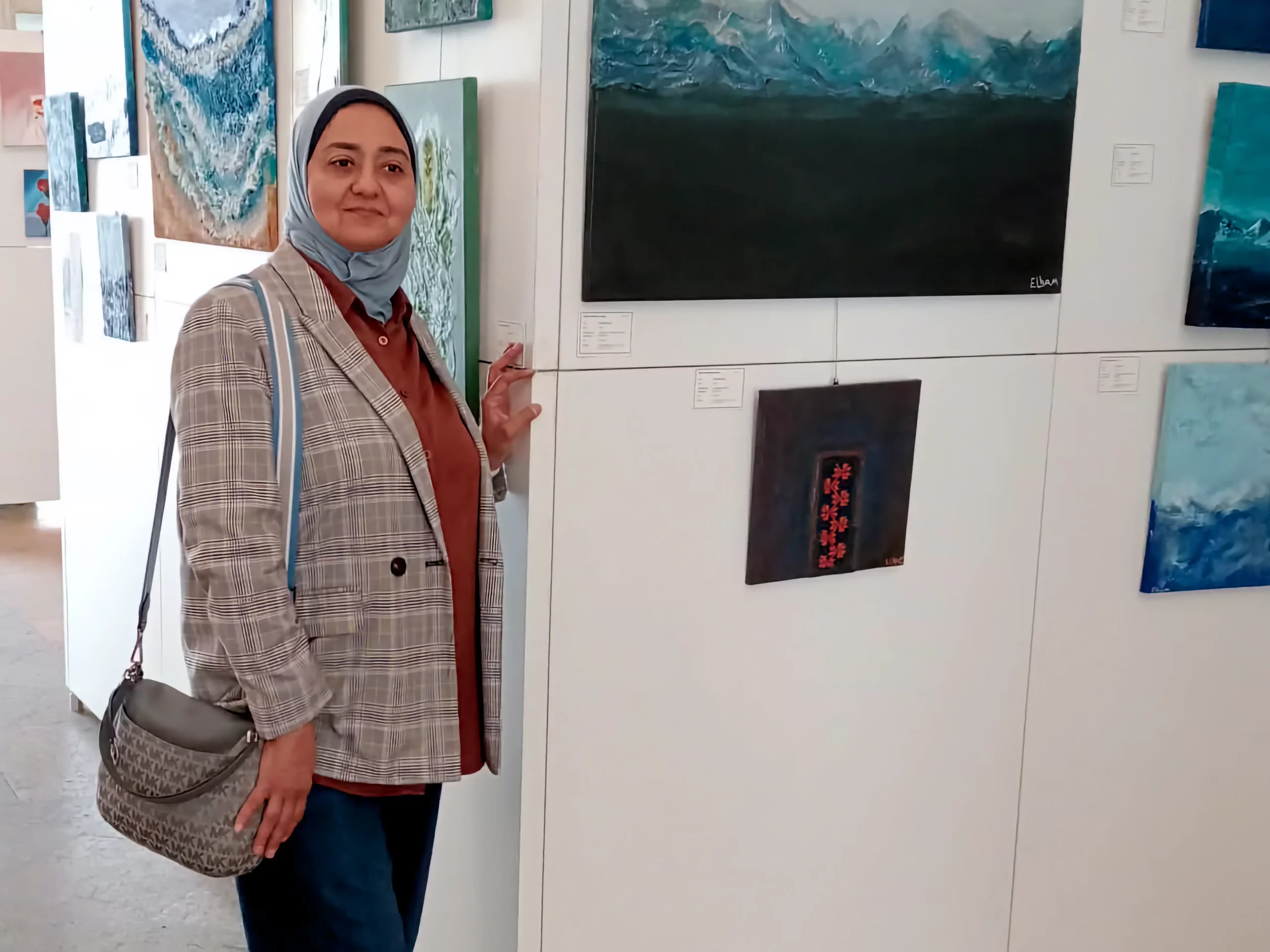Frau in einer Kunstgalerie neben abstrakten Gemälden